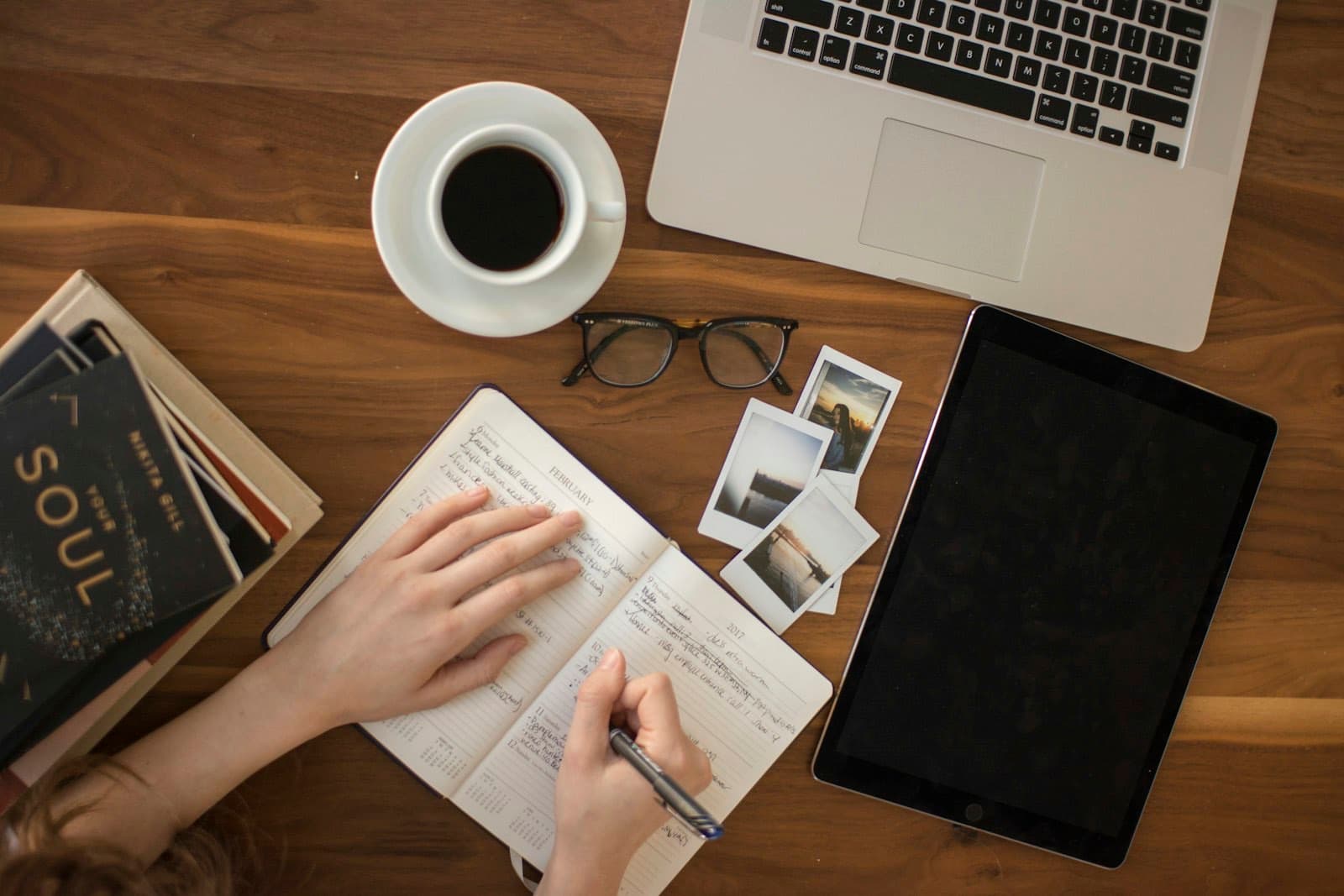Agenda ouvert, ordinateur et café sur un bureau en bois