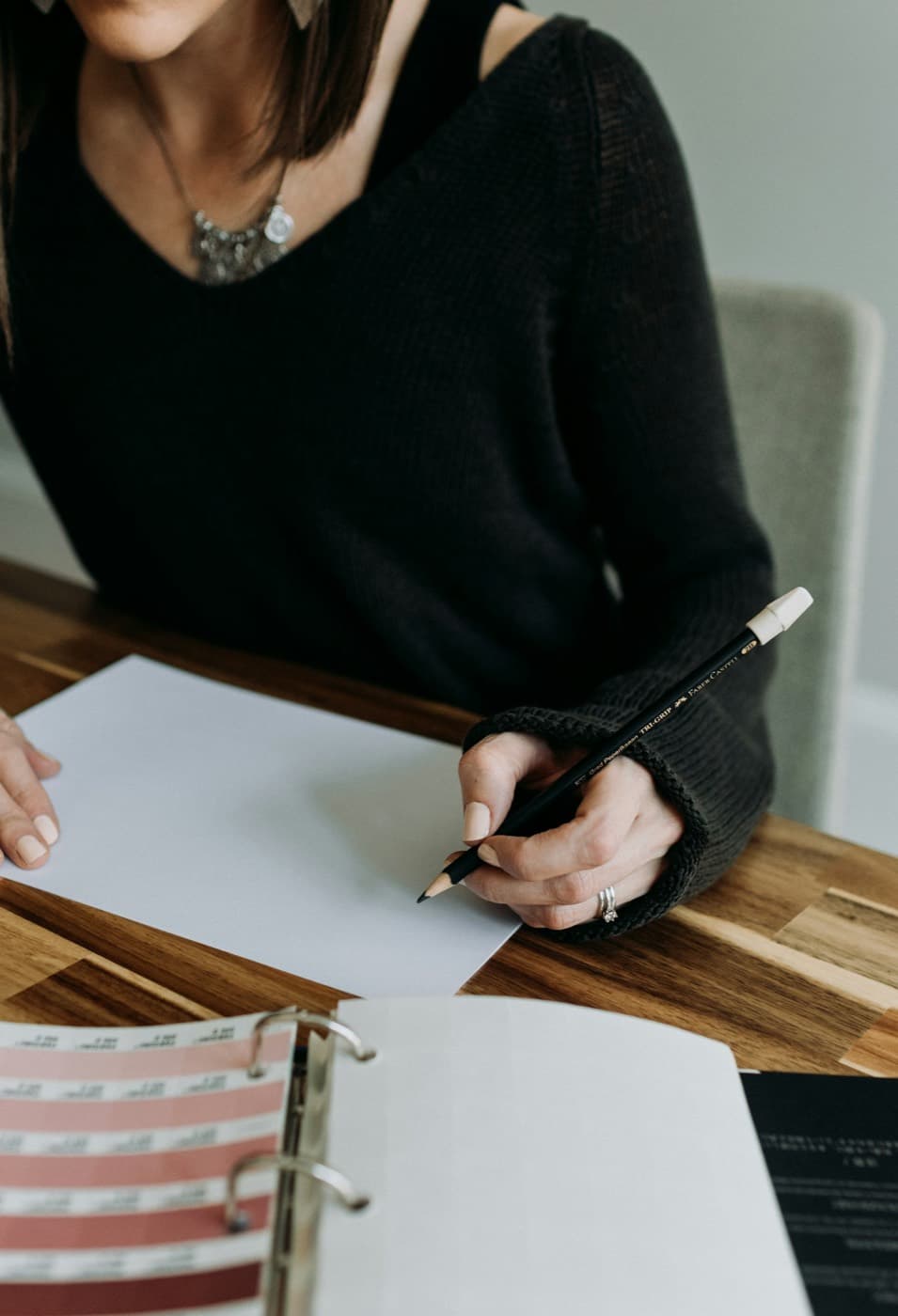 Personne complétant un classeur de travail au crayon